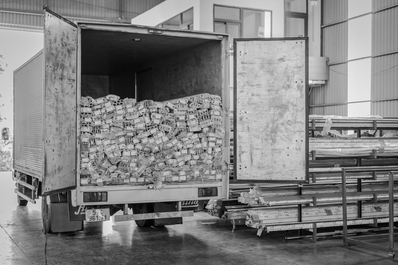 brand-02 Black and white image of an open delivery truck in an indoor warehouse setting.
