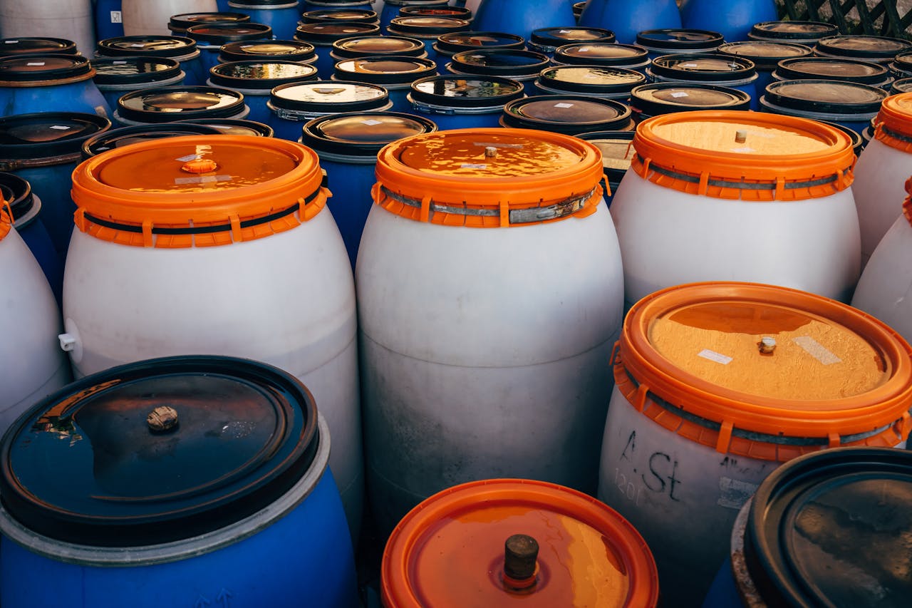 Services-03 Close-up of blue and white plastic barrels with orange lids in storage area.