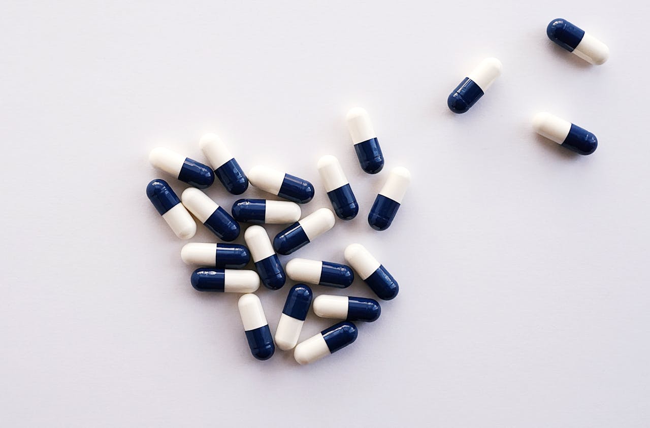 why-choose-us Flat lay of blue and white capsules arranged on a white surface, perfect for healthcare and medical themes.