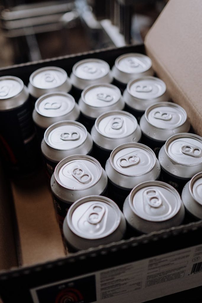 pexels-photo-5532831 Close-up of aluminum drink cans packed neatly in a cardboard box, displayed from above.
